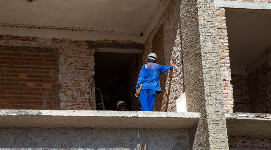 #praCegoVer Homem trabalha em uma construção