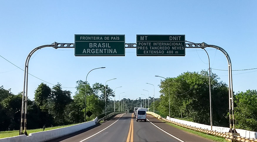 #PraCegoVer imagem de placa de estrada da fronteira entre Brasil e Argentina