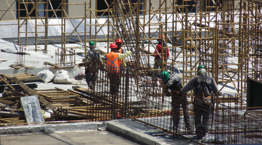#PraCegoVer operários trabalhando em uma construção