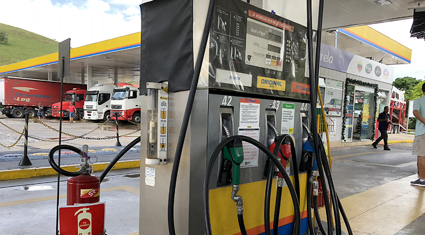 #PraCegoVer A foto um posto de gasolina. Em destaque, a bomba de gasolina colorida de amarelo e vermelho.