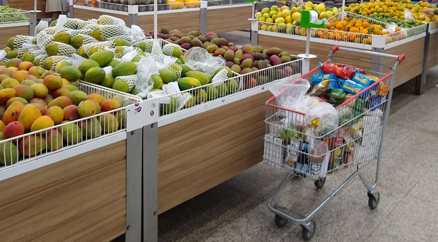#PraCegoVer A foto mostra algumas gôndolas num supermercado, com frutas e legumes diversos.