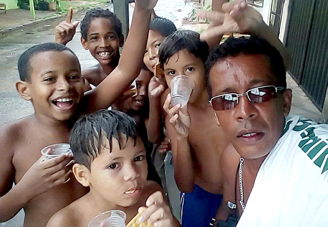 #PraCegoVer Self do voluntário José de Ribamar e as crianças que ele ajuda
