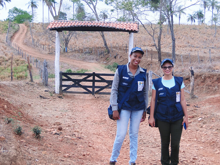 #PraCegoVer recenseadora e supervisora em frente à uma porteira de propriedade rural