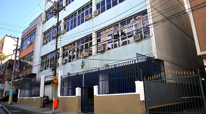 #pracegover A foto mostra parte da fachada azul da Escola Nacional de Ciências Estatísticas, localizada no bairro de Santa Teresa, no Rio de Janeiro.