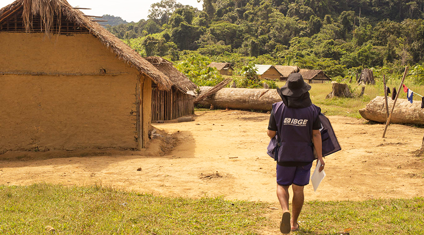 #PraCegoVer A foto mostra um recenseador do IBGE entrando numa aldeia dos Yanomamis.